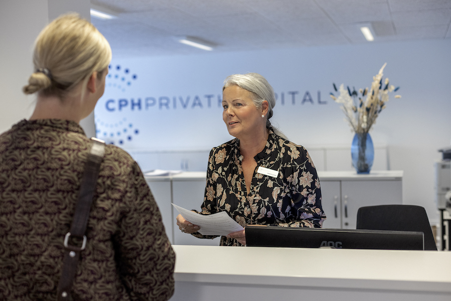 Patient ankommer til receptionen på CPH Privathospital. Her fortæller receptionisten om patientforløbet.